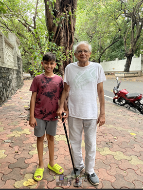Yuvaan with his grandfather, who lives with glaucoma, on a tree-lined street in their neighborhood